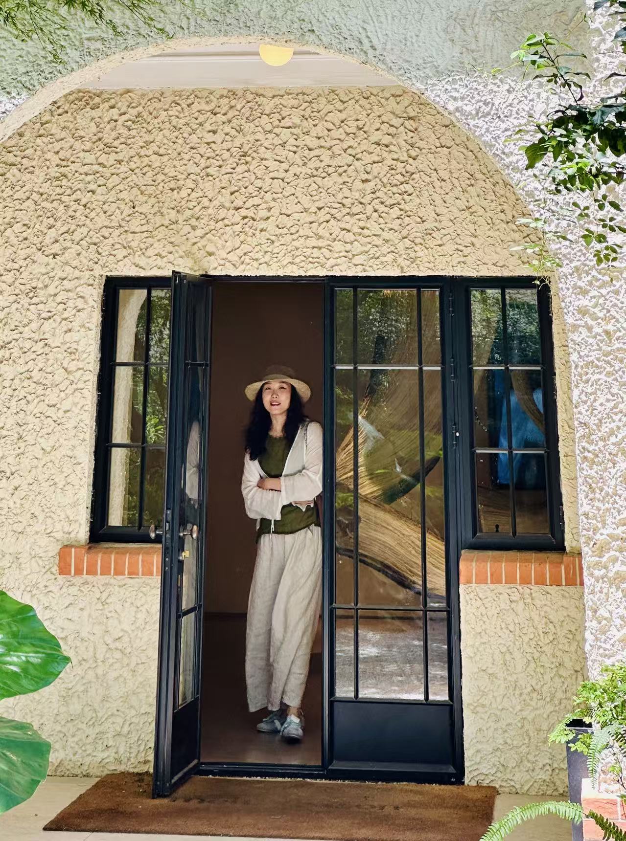 Malinna in a sunlit doorway framed by plants