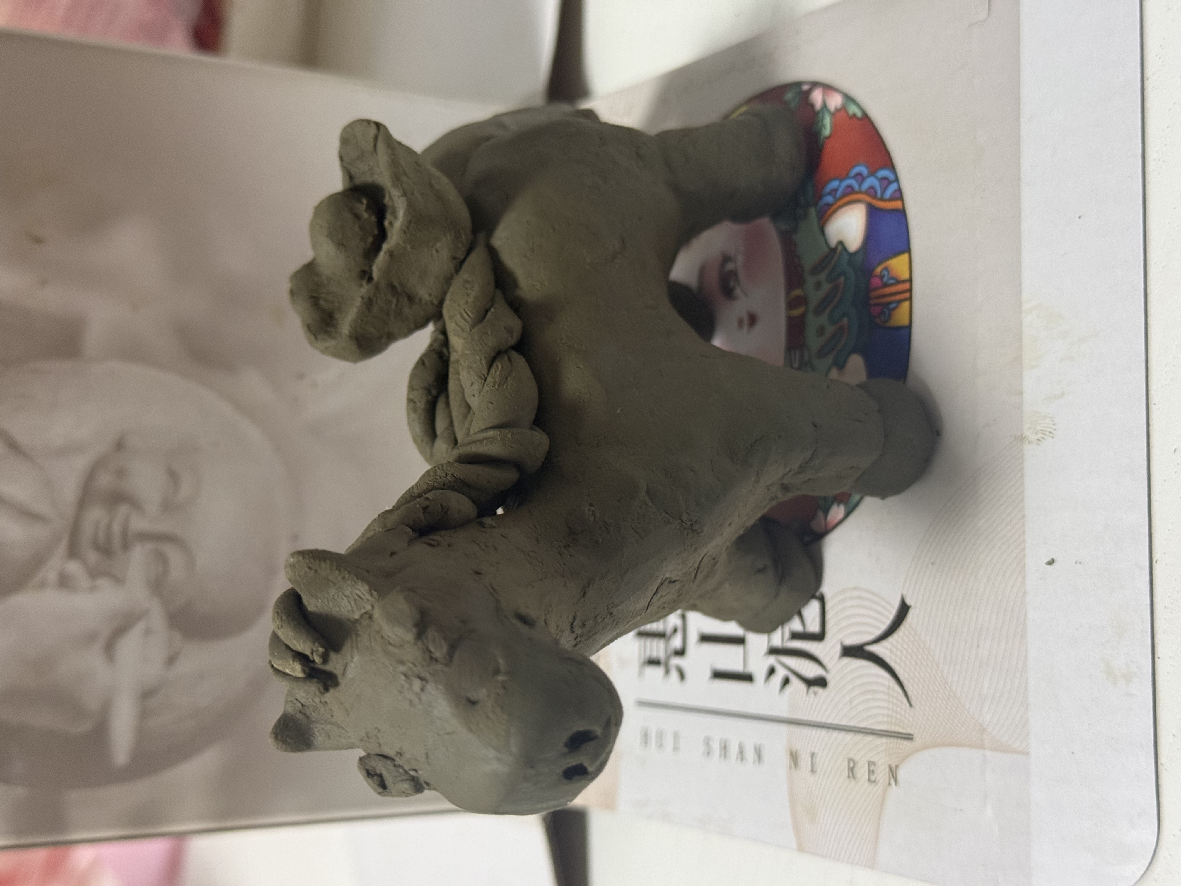 A small hand-made clay horse with a tiny rider