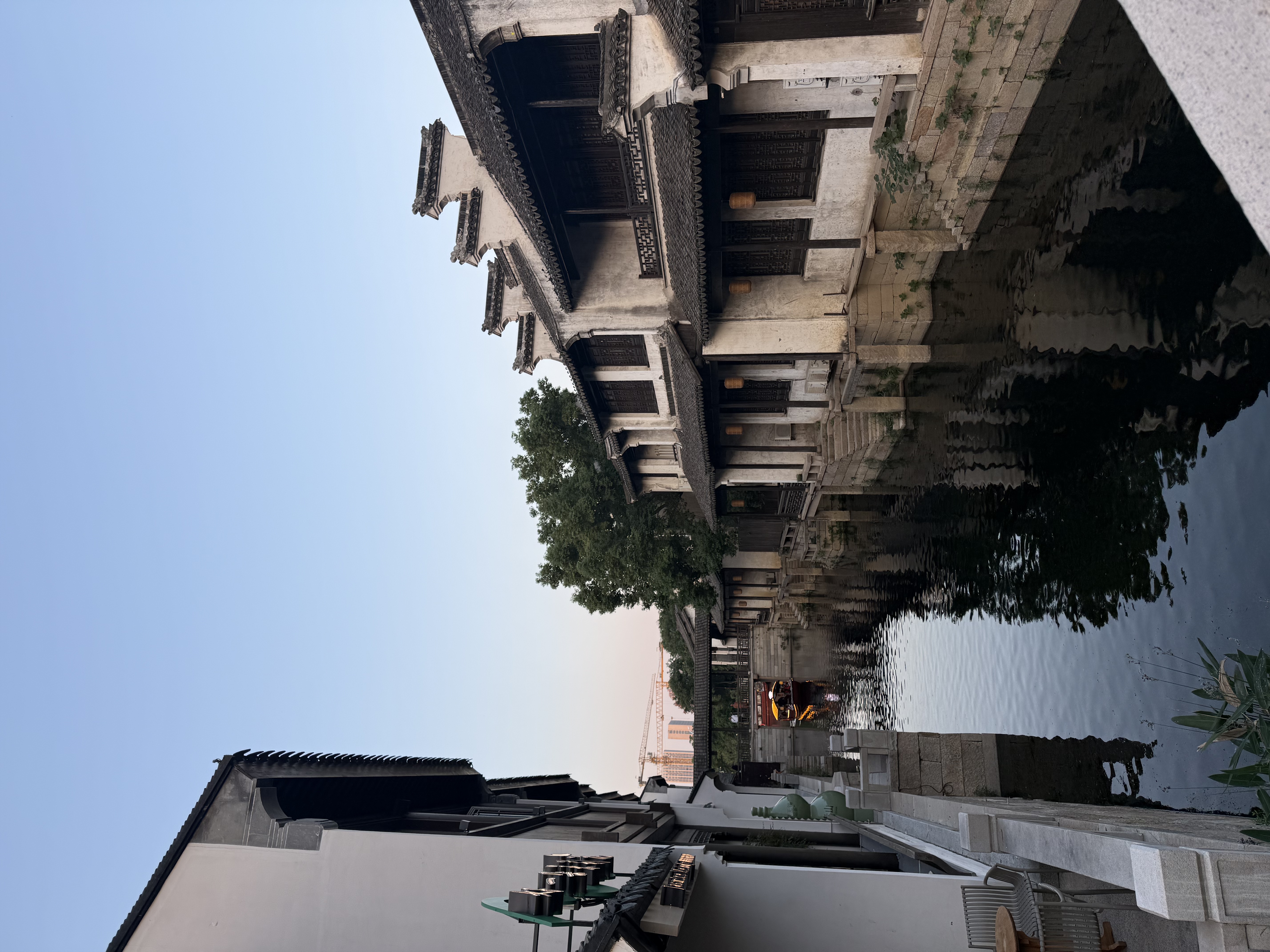 A quiet canal between traditional buildings in Wuxi at dusk
